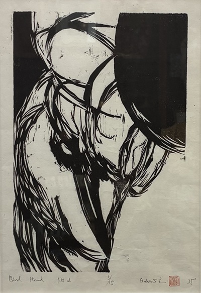 Image of a woodcut print of a bird's head in black on off-white paper.