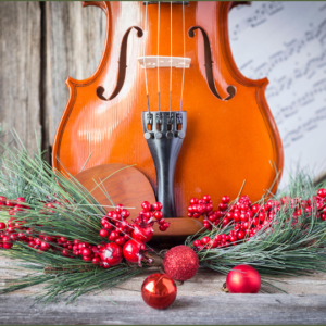 Lower half of a string instrument standing behind holiday greens, berries and decorative red balls.